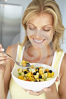 Mid Adult Woman Eating A Bowl Of Fresh Fruit