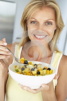 Mid Adult Woman Eating A Bowl Of Fresh Fruit