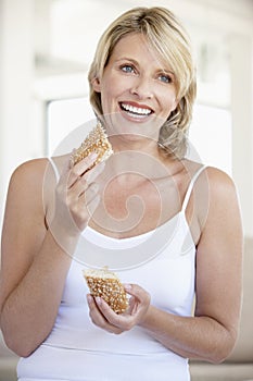 Mid Adult Woman Eating Fresh Brown Bread Roll
