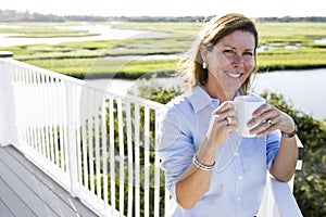 Mid-adult woman having cup of coffee on terrace