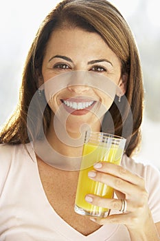 Mid Adult Woman Holding A Glass Of Orange Juice