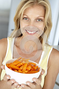 Mid Adult Woman Holding A Plate Of Carrots