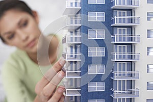 Mid adult woman inspecting architectural model close-up