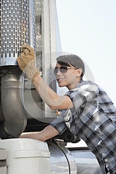 Mid adult woman inspecting timber truck