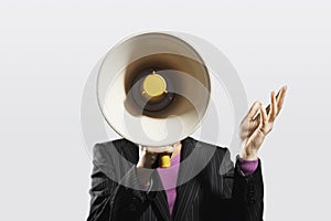 Mid-adult woman shouting through megaphone arms raised