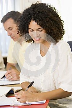 Mid adult woman studying with other adult students