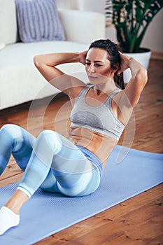 Mid adult woman training abdominals at home