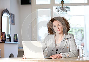 Mid adult woman using computer at home