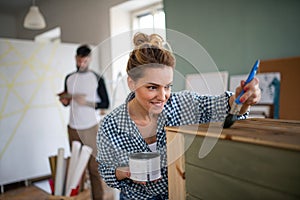 Mid adults couple painting furniture indoors at home, relocation and diy concept.