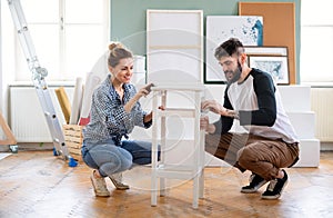 Mid adults couple renovating furniture indoors at home, relocation and diy concept.