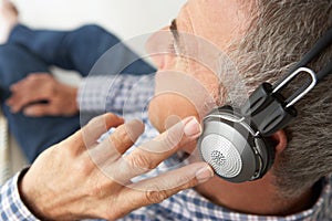 Mid ag man listening to music through headphones