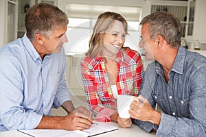 Mid age couple with financial advisor at home