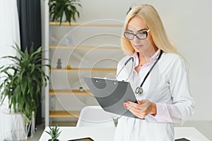 Mid age female doctor writing prescription