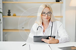 Mid age female doctor writing prescription