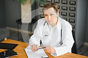 Mid age female doctor writing prescription