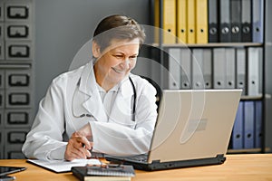 Mid age female doctor writing prescription