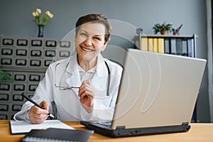 Mid age female doctor writing prescription