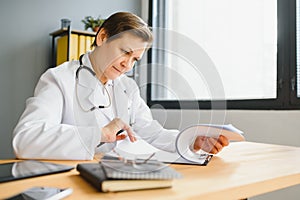 Mid age female doctor writing prescription