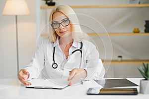 Mid age female doctor writing prescription