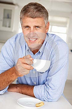 Mid age man with coffee at home