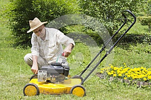 Mid age man repairing lawn mower