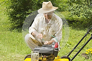 Mid age man repairing lawn mower