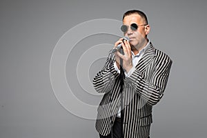 The mid age Showman interviewer with emotions. Young elegant mature man holding microphone against white background. Showman conce