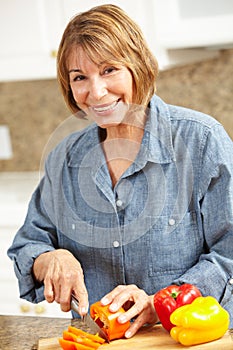 Mid age woman chopping vegetables