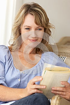 Mid age woman reading book