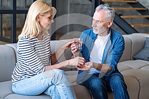 Mid age woman taking medication sitting on sofa in living room