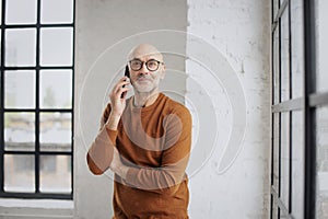 Mid aged businessman wearing casual clothes and having a call