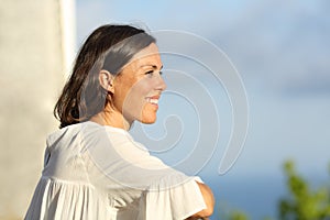 Mid aged woman contemplating from a balcony