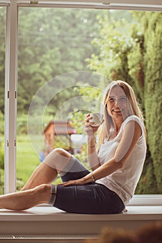 Mid-aged woman drinking coffee at home