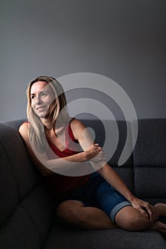 Mid-aged woman at home relaxing on a sofa