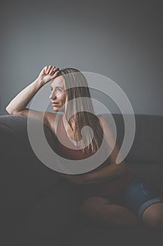 Mid-aged woman at home relaxing on a sofa