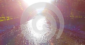 Mid air flight over fresh and clean mountain river at sunny summer morning