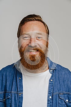 Mid bearded man in denim shirt smiling at camera standing isolated