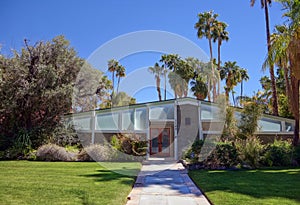 Mid-Century Modern Home with Pitched Roof and Red Glass Door at Entrance