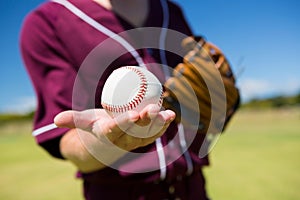 MId section of baseball pitcher holding ball on palm