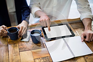 Mid-section of businesspeople using digital tablet at counter