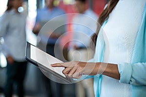 Mid section of businesswoman using digital tablet