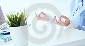 Mid section of calm businesswoman meditating at work, focus on female hands in mudra, close up view. Peaceful mindful