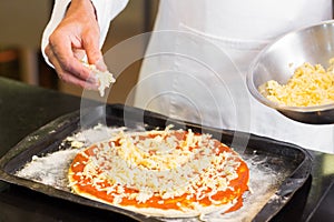 Mid section of a chef preparing pizza