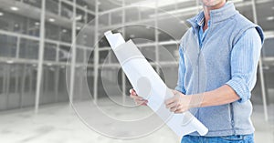 Mid section of construction engineer holding a plan