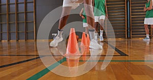 Mid section of diverse female basketball team practice dribbling ball