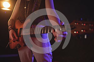 Mid section of female guitarist in music concert