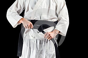 Mid section of fighter tightening karate belt