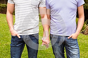 Mid section of gay couple with hand in hand