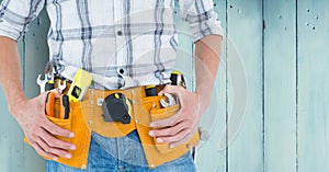 Mid-section of handy man with tool belt