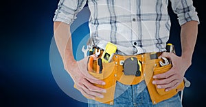 Mid section of handyman with tool belt around his waist